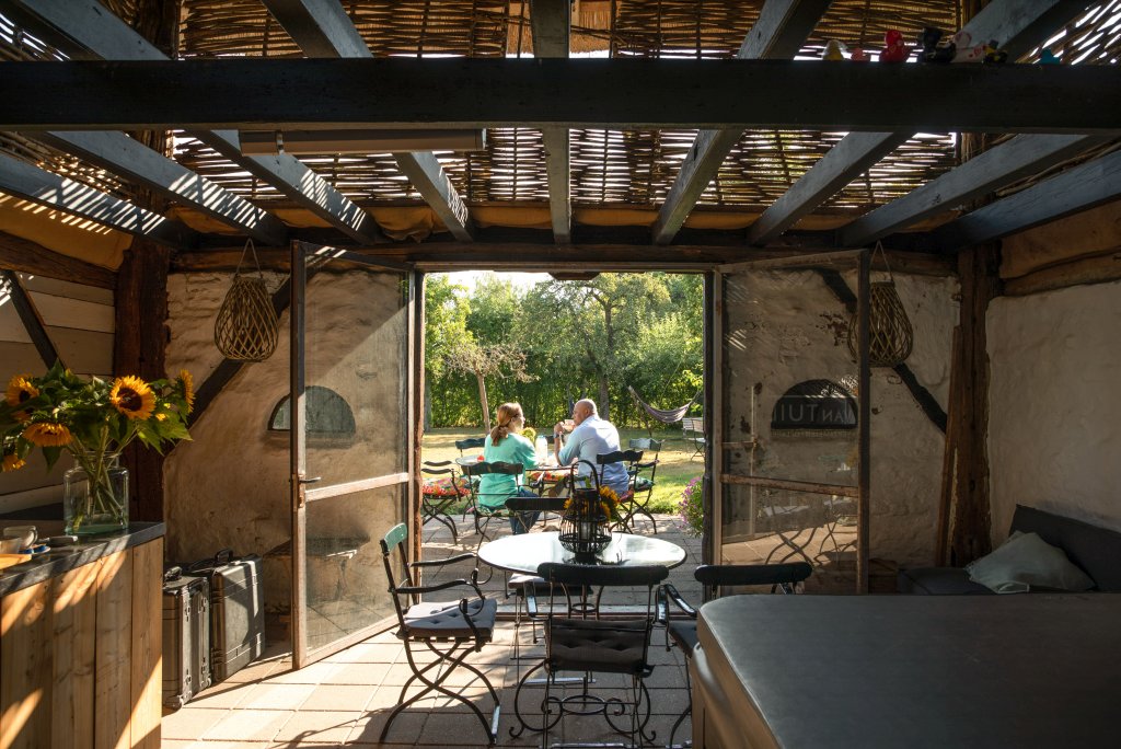 Man en vrouw aan de ontbijttafel in de tuin van De Heeren van Tuil