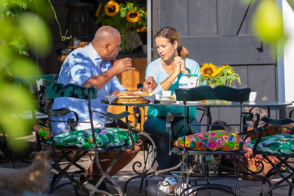 Man en vrouw aan de ontbijttafel in de tuin van De Heeren van Tuil