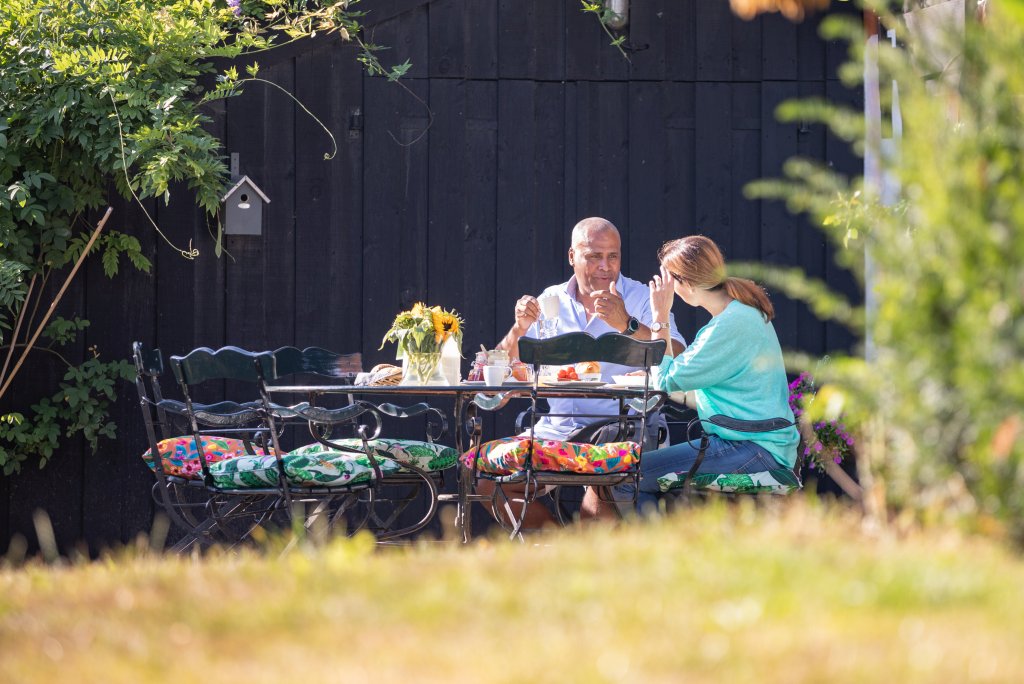 Man en vrouw aan de ontbijttafel in de tuin van De Heeren van Tuil